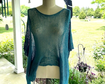 May include: Teal crochet top with a loose, open-weave design. The top is displayed on a mannequin and has a relaxed, flowy fit.