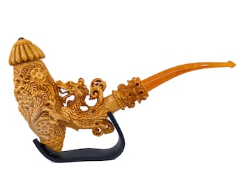 May include: A detailed, carved tobacco pipe with a dragon motif. The pipe is made of a light brown material and features intricate floral and dragon carvings. The stem is a lighter amber color, and the pipe rests on a black stand.