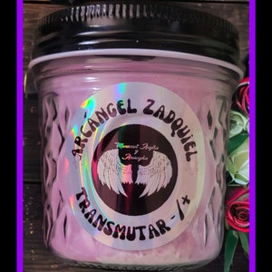 Op de afbeelding: Een roze kaars in een glazen pot met een zwart deksel. Het etiket op de pot zegt "Archangel Zadkiel Transmutar -/+" en "Manasort Angels & Archangels".