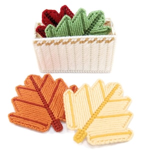 Puede incluir: Un conjunto de hojas de lona de plástico en varios colores, incluyendo rojo, verde, naranja y amarillo. Las hojas están en una cesta de lona de plástico blanca con un borde dorado.