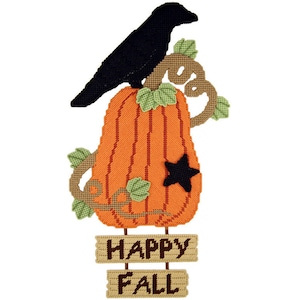 Puede incluir: Un cuervo negro posado sobre una gran calabaza naranja con hojas verdes y una estrella negra. La calabaza está sobre un letrero de madera que dice "Happy Fall".