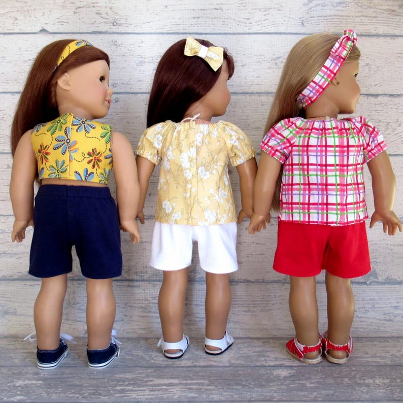 This photo shows the back of three of the summer outfits for 18 inch dolls.