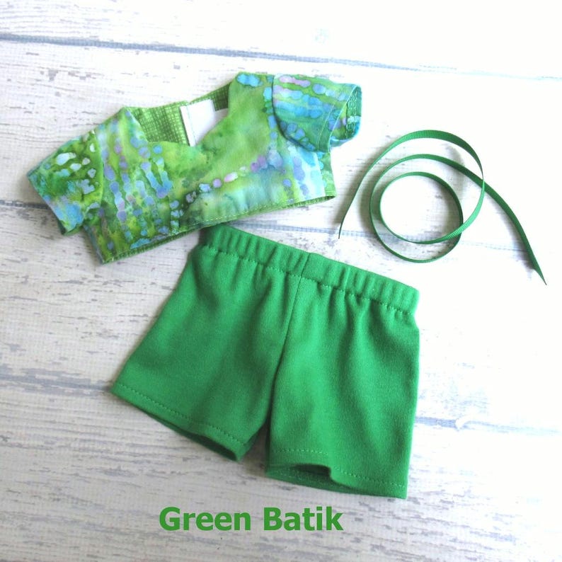 This summer set for your 18 inch doll includes a crop top made of green batik fabric; a pair of green stretch knit shorts, and a length of green grosgrain ribbon your doll can tie into a headband.