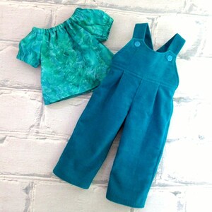 Shirt and overalls laid flat.