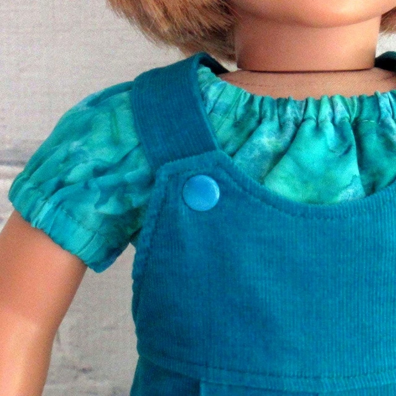 Closeup view of shirt sleeve and overall snaps.