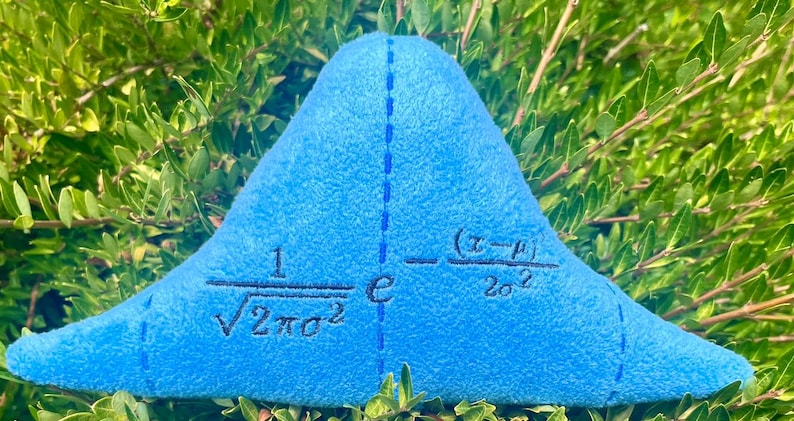 May include: A blue plush pillow shaped like a bell curve with the mathematical formula for a normal distribution embroidered on it. The formula is 1/&radic;2&pi;&sigma;&sup2; * e^-(x-&mu;)&sup2;/2&sigma;&sup2;.