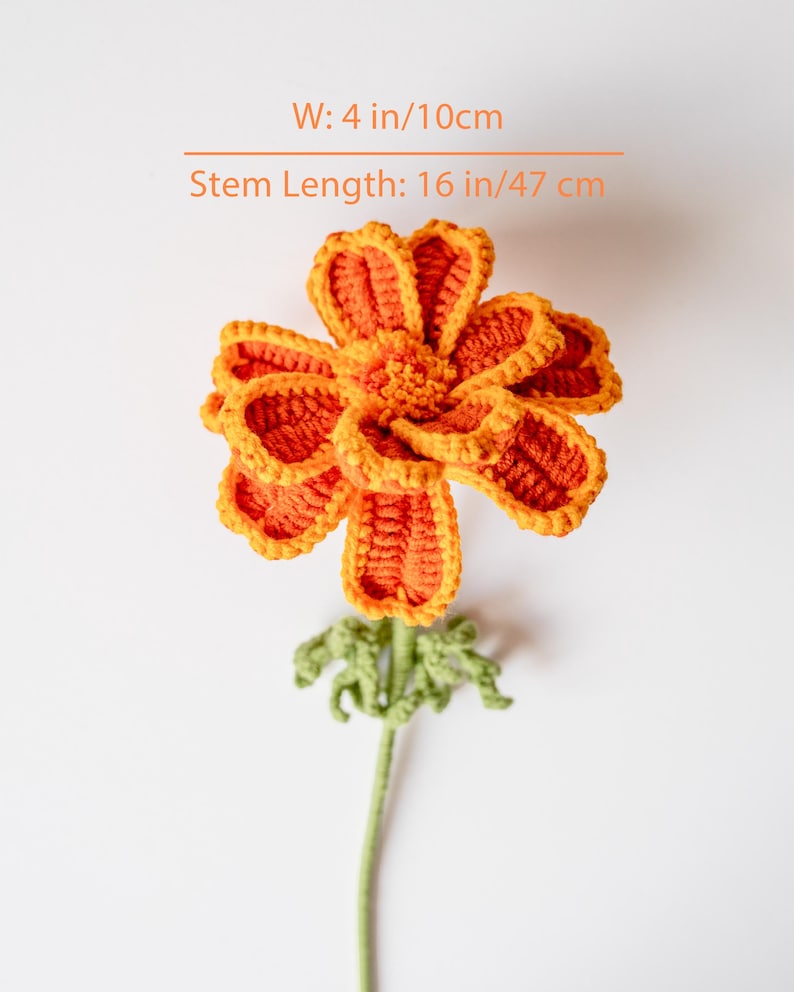 May include: A handmade crochet flower in shades of orange and yellow, with a green stem and leaves. The flower is 4 inches wide and the stem is 16 inches long. The text on the image reads: W: 4 in/10cm, Stem Length: 16 in/47 cm.