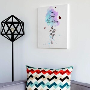 May include: A canvas print with the words "I am Enough Still and always" in script, with watercolor accents and floral details. A decorative pillow with a zig-zag pattern in red, black, teal, and beige. A black geometric lamp.