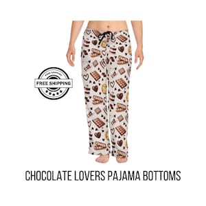 May include: Chocolate lovers pajama bottoms with a repeating pattern of chocolate bars, hearts, and desserts on a cream background. The pajama bottoms have a black drawstring and the text "CHOCOLATE LOVERS PAJAMA BOTTOMS".