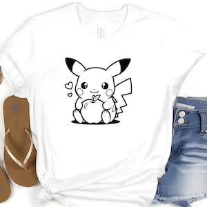 May include: A white t-shirt with a black and white cartoon image of Pikachu holding an apple.