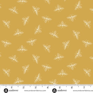 May include: A yellow fabric with a white bee pattern. The fabric is from Andover Fabrics and has a ruler for scale.