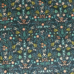 Peut inclure: Tissu bleu canard fonc&eacute; avec un motif floral r&eacute;p&eacute;t&eacute;. Le motif pr&eacute;sente de petites fleurs blanches, p&ecirc;che et bleues, ainsi que des feuilles et des tiges vertes et jaunes. Le tissu est probablement du coton ou une mati&egrave;re similaire, adapt&eacute; aux projets de couture.