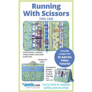 Op de afbeelding: Een blauwe en groene stoffen gereedschapskoffer met de titel "Running With Scissors" en de tekst "Tool Case". De koffer is open en toont verschillende scharen, markers en andere gereedschappen. De koffer heeft vakken voor linialen. De afbeelding bevat ook een coupon voor een extra video-tutorial voor € 5.