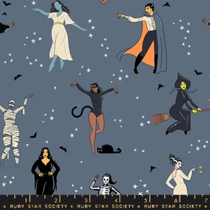 Può includere: Un tessuto blu con un motivo ripetuto di vari personaggi di Halloween, tra cui una strega, un vampiro, una mummia, uno scheletro, un gatto e un fantasma. I personaggi sono tutti vestiti in costume e sono circondati da stelle.
