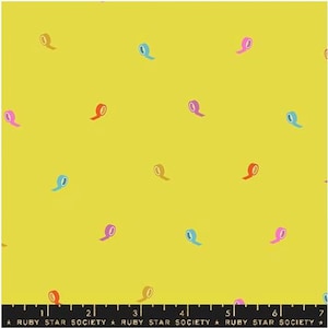 Pode incluir: Tecido amarelo com um padrão repetitivo de rolos de fita coloridos em rosa, azul e vermelho. O texto "RUBY STAR SOCIETY" está impresso ao longo da borda inferior.