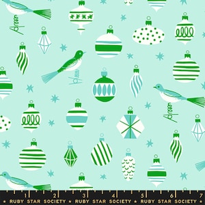 Puede incluir: Una tela de color verde menta claro con un patrón repetitivo de adornos navideños blancos y verdes de diversas formas, incluyendo esferas, gotas y hexágonos, intercalados con pequeños pájaros y estrellas. El borde inferior muestra una regla negra.