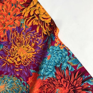 May include: A vibrant fabric with a floral pattern featuring large, colorful chrysanthemums in shades of orange, red, purple, blue, and yellow. The background is a deep magenta.