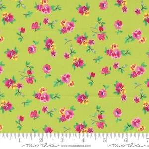 May include: Green fabric with a small pink and yellow floral print. The fabric is shown with a ruler for scale.