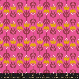 May include: A pink fabric with a repeating pattern of yellow stylized flowers with white dots. The fabric has a black ruler with white markings and the text "RUBY STAR SOCIETY" printed on it.