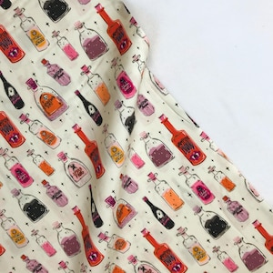 May include: A white fabric with a repeating pattern of colorful potion bottles. The bottles have various labels with text such as "Vampire Blood", "Sewer Fins", and "Howl Worries".