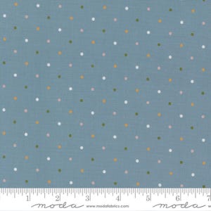 May include: Blue fabric with a repeating pattern of small, evenly spaced polka dots in white, pink, green, and gold. The fabric has a ruler along the bottom edge with the word "moda" printed on it.