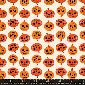 Puede incluir: Un patrón repetitivo de calabazas naranjas con rasgos faciales negros y mejillas rosadas sobre un fondo crema. Una regla negra con marcas blancas y el texto "RUBY STAR SOCIETY" es visible en la parte inferior, midiendo 18 cm.