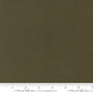 May include: Olive green fabric with a subtle herringbone pattern. The fabric has a textured appearance and a ruler is at the bottom of the image. The fabric is suitable for quilting, sewing, and various craft projects.