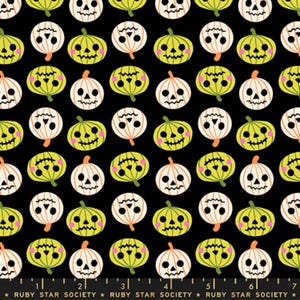 Peut inclure: Un tissu noir avec un motif répétitif de citrouilles d'Halloween en vert citron et blanc. Chaque citrouille présente un visage sculpté avec des yeux noirs et une bouche dentelée, rehaussé de joues roses. Une règle en bas indique 18 cm.