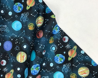 May include: A dark blue fabric with a repeating pattern of planets, stars, and constellations. The planets are painted in various colours, including yellow, orange, red, blue, and green. The stars are white and the constellations are white lines.