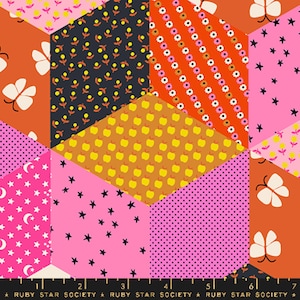 Puede incluir: Una tela colorida con un diseño de patchwork que presenta varias formas geométricas y patrones. La tela incluye motivos de estrellas, lunas, mariposas, manzanas y flores en tonos de rosa, naranja, amarillo y negro.