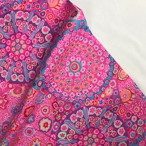 Könnte beinhalten: Ein leuchtend rosa Stoff mit einem sich wiederholenden Blumenmuster in Rosa-, Lila- und Blautönen. Das Design zeigt kreisförmige Motive mit detaillierten floralen und geometrischen Elementen, wodurch ein lebendiges und farbenfrohes Textil entsteht.