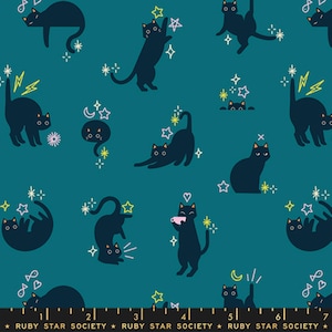 May include: A teal fabric featuring a repeating pattern of black cats in various poses, including stretching, sitting, and playing. The design includes small yellow and white stars, lightning bolts, hearts, and fish icons. A ruler at the bottom shows 18 cm.