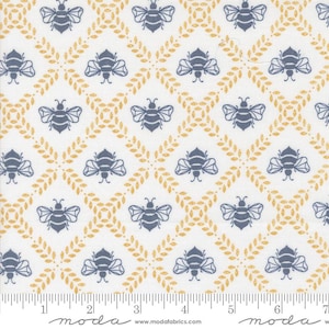 May include: White fabric with a repeating pattern of blue bees and gold leaf-like designs. The bees are stylized with detailed wings and bodies. The fabric has a ruler along the bottom with the word "moda" printed on it.