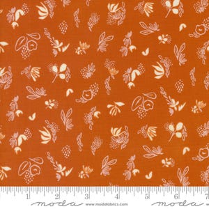 May include: A rust-coloured fabric with a white floral pattern. The pattern features small flowers, leaves, and dots. The fabric is ideal for quilting, sewing, and crafting.