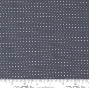 May include: Close-up of a fabric with a dark blue background and small white polka dots. The fabric is measured with a ruler at the bottom. The fabric is from Moda Fabrics.