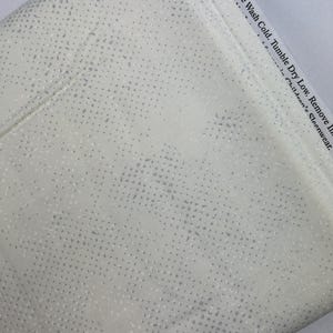 May include: White fabric with a subtle silver dot pattern. Machine wash cold, tumble dry low. Remove if children's sleepwear.