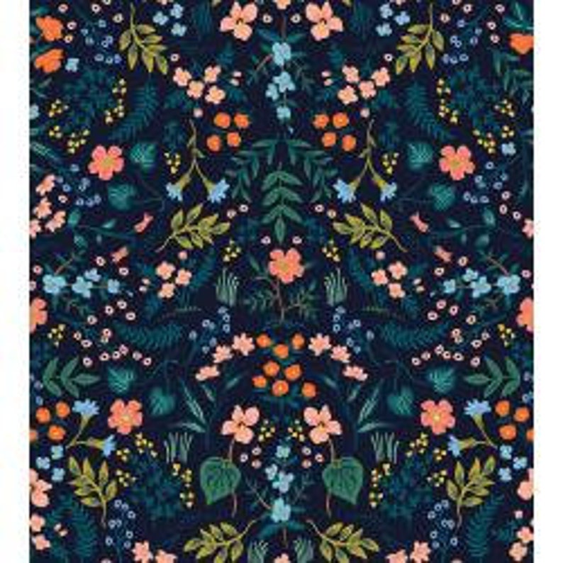 Peut inclure: Un tissu floral bleu marine fonc&eacute; avec un motif sym&eacute;trique. Le motif pr&eacute;sente une vari&eacute;t&eacute; de fleurs dans les tons p&ecirc;che, bleu et jaune, ainsi que des feuilles et des tiges vertes. Le tissu est dens&eacute;ment rempli de l'arrangement floral.