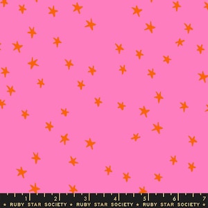 May include: Pink fabric with a repeating pattern of orange stars. The fabric has a ruler printed at the bottom with the text "RUBY STAR SOCIETY" repeated.
