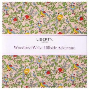 Könnte beinhalten: Rosafarbener Stoff mit einem sich wiederholenden Muster aus bunten Vögeln und grünen Blättern. Der Stoff trägt den Text "LIBERTY. FABRICS" und "Woodland Walk: Hillside Adventure".