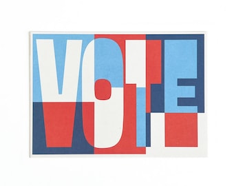 Puede incluir: Una tarjeta rectangular con la palabra "VOTE" en letras grandes y superpuestas. Las letras son blancas, rojas y azules, con un diseño geométrico. El fondo es blanco.