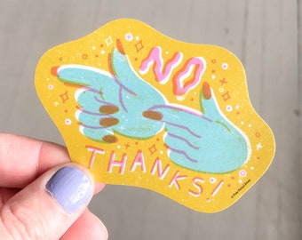 May include: A yellow sticker with a unique design featuring two blue hands forming a 'no' gesture. The word 'NO' is in pink, and 'THANKS!' is in pink. The sticker has a textured appearance with small decorative elements.