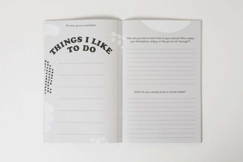 K&ouml;nnte beinhalten: Ein grau-wei&szlig;es Journal mit dem Text "Things I Like To Do" auf dem Cover. Das Journal hat linierte Seiten zum Schreiben. Der Text "Pin this up as a reminder!" steht oben auf der Seite. Das Journal hat zwei Seiten offen, mit Fragen zu sozialen Medien und wer Sie gerne am Telefon h&ouml;ren.