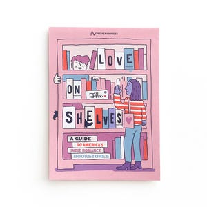 以下が含まれることがあります： 「Love on the Shelves: A Guide to America's Indie Romance Bookstores」というタイトルのイラスト入りのガイド。表紙はピンクで、本棚に本が置かれ、人が本を持っている様子が描かれている。