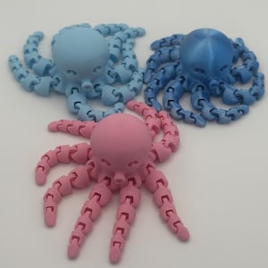 May include: Three articulated octopus toys, one blue, one pink, and one light blue. Each octopus has eight flexible arms.