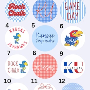May include: A collection of twelve pinback buttons with various designs and text, including "Rock Chalk," "KU," "Game Day," and "Kansas Jayhawks." The buttons feature a variety of colors and patterns, such as gingham, stripes, and polka dots. The text "University of Kansas" is at the top.