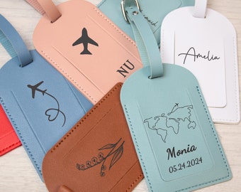 Può includere: Cinque diversi cartellini per bagagli in pelle di colori diversi con vari disegni. I cartellini sono marroni, rossi, rosa, blu e bianchi. I disegni includono un aereo, un cuore, fiori, una mappa del mondo e un nome.