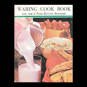 May include: A vintage cookbook cover featuring a pink milkshake being poured into a glass. The cover also shows a strawberry dessert, a salad with a creamy dressing, and a basket of bread. The title of the book is "Waring Cook Book for the 8 Push Button Blender".