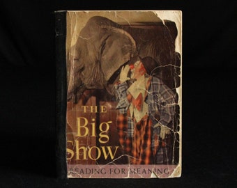 Può includere: Copertina di libro vintage con un'illustrazione colorata di un clown e un elefante. Il titolo del libro è "The Big Show" e il sottotitolo è "Reading for Meaning".