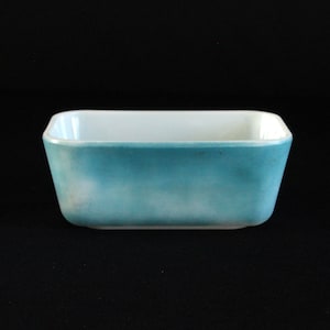 Puede incluir: Un plato para hornear rectangular de vidrio azul claro con un borde blanco.