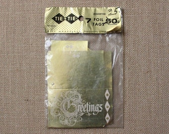 May include: A package of 7 gold foil gift tags with the words "Greetings" printed on them. The package is labeled "Tie-Tie" and "Assorted Foil Tags 25c 50c".